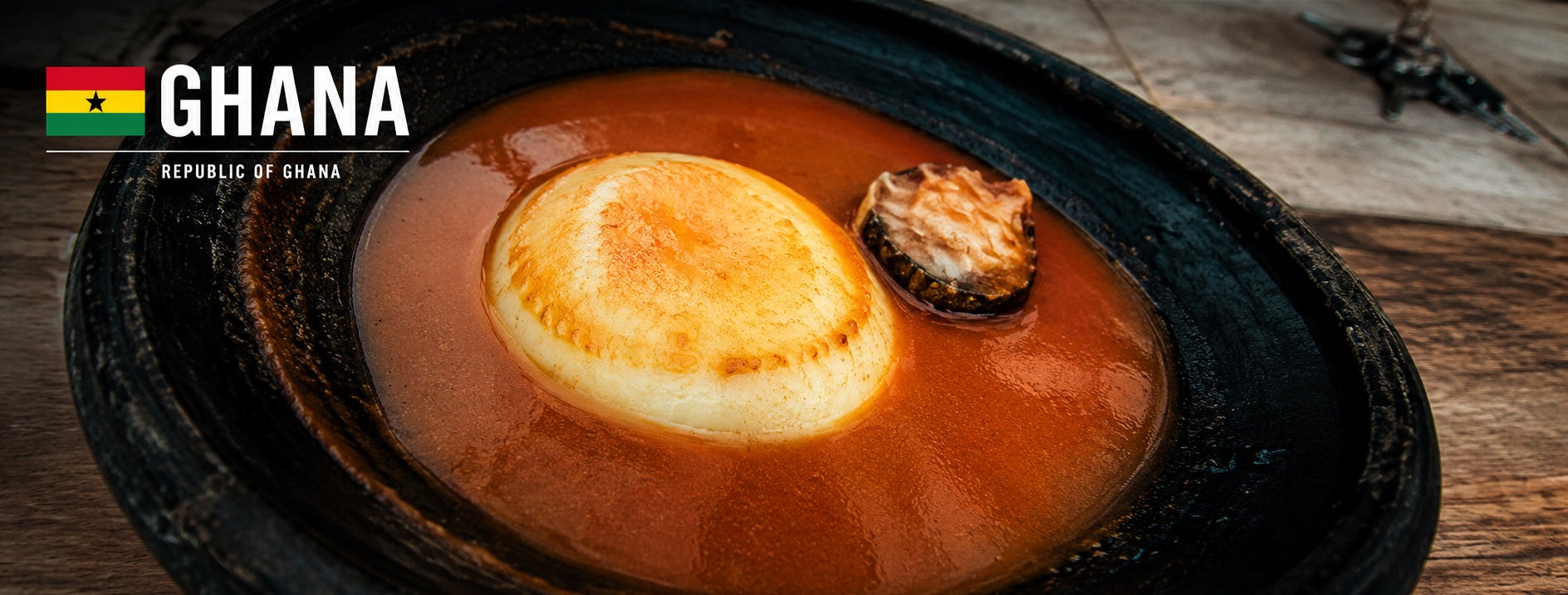 Cinematic banner showing traditional Ghanaian Fufu served in soup with fish, featuring the Ghanaian flag and the country's name on a widescreen title image.