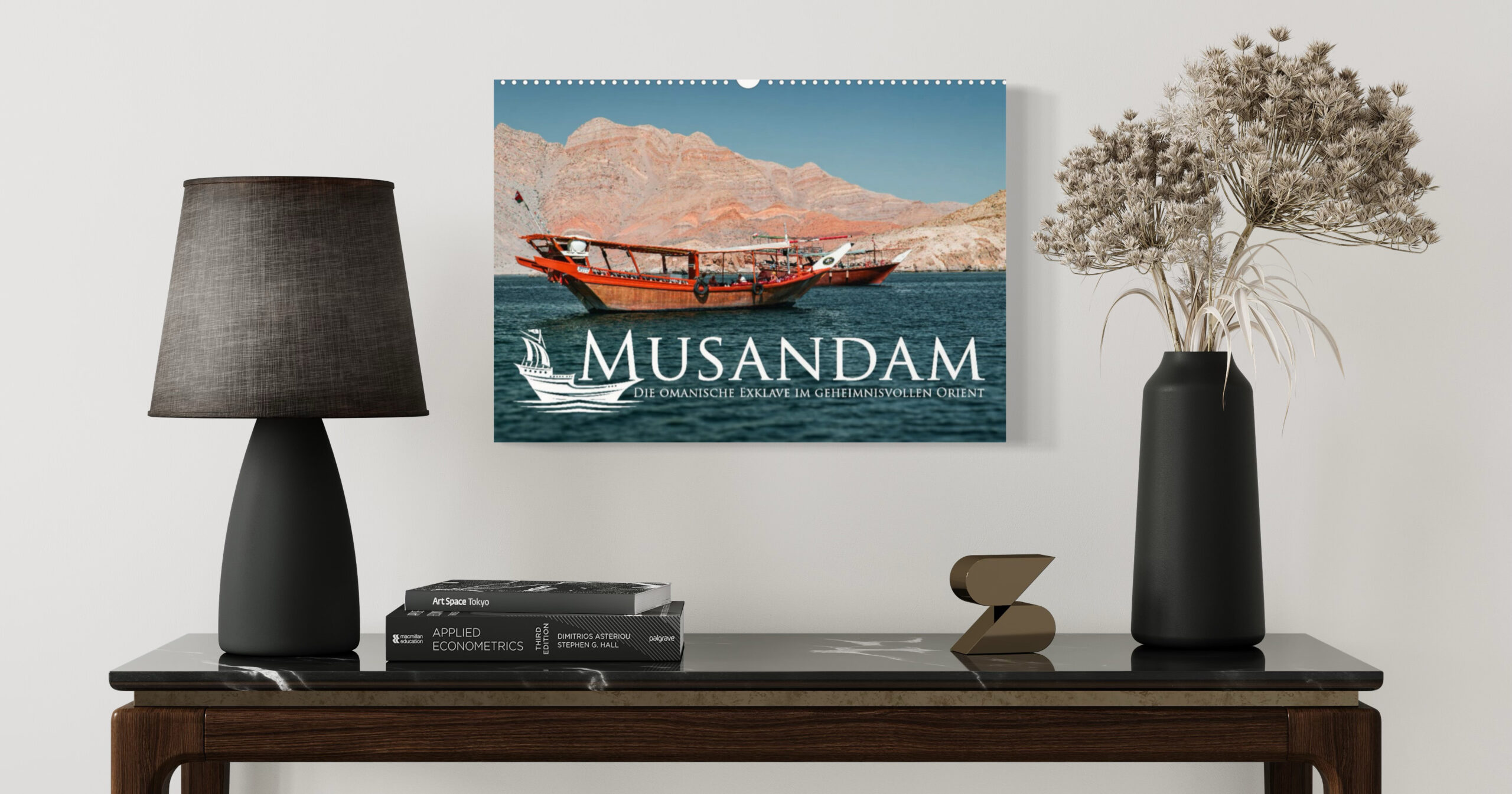 Travel calendar featuring Musandam, Oman, displayed on a console table between two black lamps